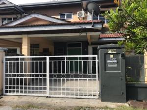 a white fence in front of a house at Lungo Guesthouse in Kuala Terengganu