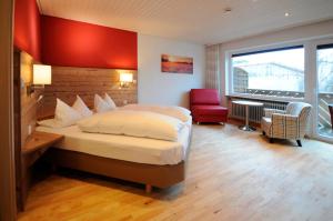 a hotel room with a bed and a red wall at Wildkräuter-Gasthof Linde in Löffingen