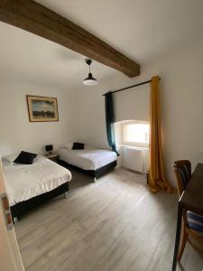 a bedroom with two beds and a window in it at L'annexe du Château de Saint Genix in Saint-Genix-sur-Guiers