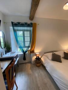 a bedroom with a bed and a desk and a window at L'annexe du Château de Saint Genix in Saint-Genix-sur-Guiers