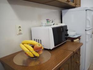 a bowl of fruit on a counter next to a microwave at Holiday home TONČICA - Rogotin in Rogotin