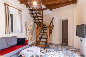 a living room with a couch and a spiral staircase at Villa Peleziki in Kos