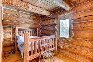 Dormitorio en cabaña de madera con cama y ventana en Stay at the Treeline with Fabulous Views! On Top of the World at Ptarmigan Lodge, en Fairplay