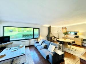 ein Wohnzimmer mit einem blauen Sofa und einem Tisch in der Unterkunft VILLA GUIMIL - GALICIA PLAYA in Villarmayor