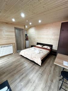 ein Schlafzimmer mit einem großen Bett in einem Holzzimmer in der Unterkunft Magic Box in Constanţa