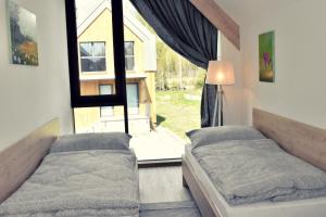 1 Schlafzimmer mit 2 Betten und einem großen Fenster in der Unterkunft Chata3brezy Vysoké Tatry in Stará Lesná