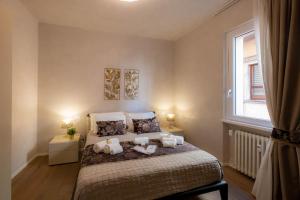 1 dormitorio con cama con almohadas y ventana en Verona Romana Apartments en Verona