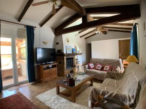 a living room with a couch and a tv at Villa La Rose des Vents in Tourrettes