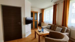 a living room with a couch and a tv at Pension Glückstadt in Glückstadt