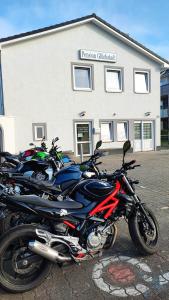 une rangée de motocycles garés devant un bâtiment dans l'établissement Pension Glückstadt, à Glückstadt