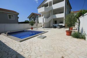 a backyard with a swimming pool and a house at Apartmani Srdanovic in Tivat