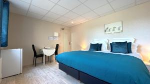 een hotelkamer met een groot bed en een tafel bij Hôtel des quatre saisons in Guérande