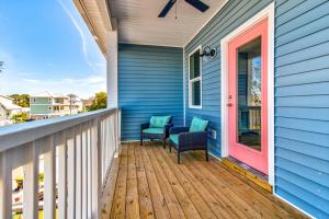 een veranda met 2 stoelen en een roze deur bij #1 Mack in Carolina Beach