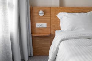 una camera con letto e testata in legno di Townhouse Lefkada a Città di Lefkada