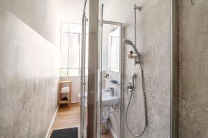 La salle de bains est pourvue d'une douche, d'un lavabo et d'un miroir. dans l'établissement The lemon tree house - Bellagio center, à Bellagio