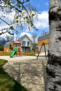 einen Spielplatz mit einer grünen Rutsche neben einem Haus in der Unterkunft Chata3brezy Vysoké Tatry in Stará Lesná