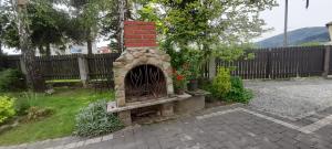 a brick fireplace in a yard next to a fence at Agroturystyka u Wiesi in Cięcina