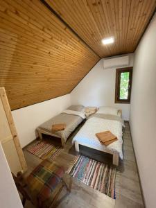 - 2 lits dans une chambre dotée d'un plafond en bois dans l'établissement Perényi Pince és Vendégház Hajós, à Hajós