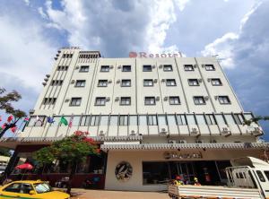 a white building with a sign on top of it at Resotel in Maputo