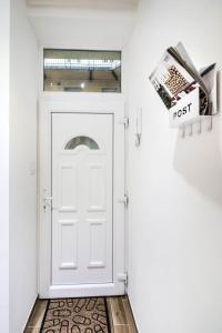 una puerta blanca en un pasillo con un periódico en BOX Studio in Ruin Pub District, en Budapest