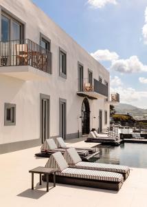 a hotel room with a balcony overlooking the ocean at White Exclusive Suites & Villas in Lagoa