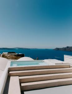 uma piscina ao lado de uma casa com escadas em Spitia Santorini Villa Collection em Oia mais 37 fotografias