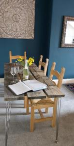 a wooden table with chairs and a table with flowers on it at The Farrier in Cheltenham