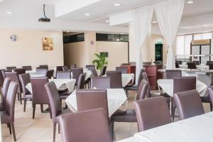 a dining room with white tables and chairs at Resotel in Maputo