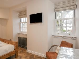 a bedroom with a bed and a tv on a wall at Oak Cottage in Windermere