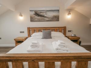 a bedroom with a bed with towels on it at Oak Cottage in Windermere