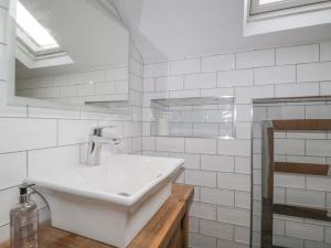 a white bathroom with a sink and a mirror at Oak Cottage in Windermere +38 photos