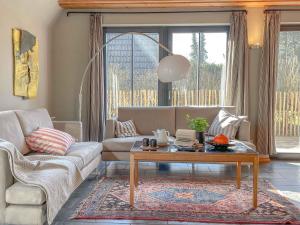 a living room with a couch and a coffee table at traumHaff - Strandhaus am Achterwasser. Design und Kunst auf Usedom, mit Kamin und Sauna in Quilitz