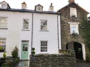 an old stone house with a green door at Oak Cottage in Windermere