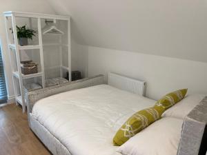 een slaapkamer met een bed en een witte plank bij Debussys Guest House in Saffron Walden