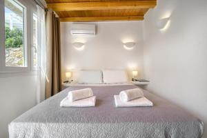 a bedroom with a bed with two pillows on it at Anius Apartments in Mikonos