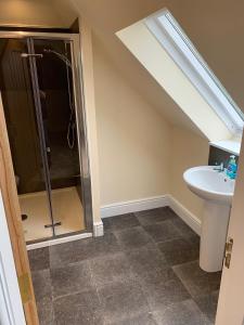 a bathroom with a shower and a sink at Highland Farm Cottages in Dingwall