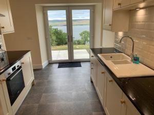 a kitchen with a sink and a large window at Highland Farm Cottages in Dingwall