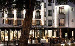 hotel ze stołami i krzesłami przed budynkiem w obiekcie Le Celtique & Spa w mieście Carnac