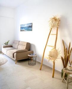 sala de estar con sofá y planta en Atop gold luxury suites, en Ermoupoli