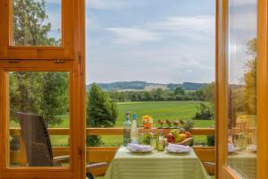 a dining room with a table with a view of a green field at Hotel An Der Brunnader - Ihr perfekter Rückzugsort in der Bayrischen Toskana in Bad Birnbach