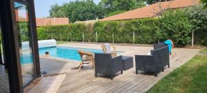 eine Terrasse mit Stühlen und einem Pool in der Unterkunft Maison landaise moderne piscine chauffée spa in Lit-et-Mixe