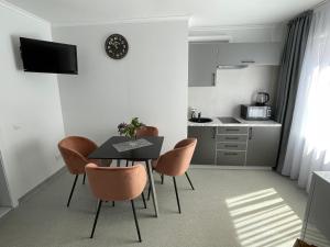 Apartamentai Rokiškio Senamiestyje في روكيسكيس: غرفة طعام مع طاولة وكراسي ومطبخ