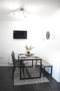 a dining room with a table and a chair at Maya Boutique Inn - Garden - Sleeps 6 in Wythenshawe