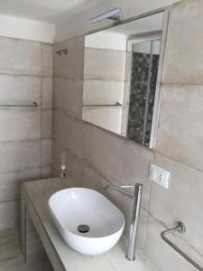 ein Badezimmer mit einem weißen Waschbecken und einem Spiegel in der Unterkunft SALENTO - Acquarica del Capo - Lecce in Acquarica del Capo