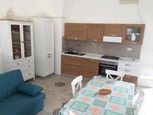 kuchnia ze stołem i niebieską kanapą w obiekcie SALENTO - Acquarica del Capo - Lecce w mieście Acquarica del Capo