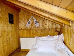 ein Schlafzimmer mit einem Bett in einer Holzwand in der Unterkunft Premium mountain view chalet in Borşa