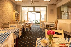 un ristorante con tavoli, sedie e fiori in una stanza di The Hurstmere a Blackpool