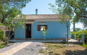 una piccola casa blu con un albero di The Little House Corfu ad Áno Korakiána