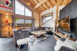 ein Wohnzimmer mit Sofas und einem Tisch in der Unterkunft Chalet Paradis Blanc Morzine in Morzine