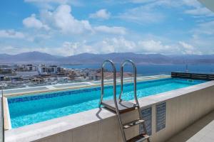 una piscina con una silla en el balcón en Geffen penthouse pool & view, en Eilat